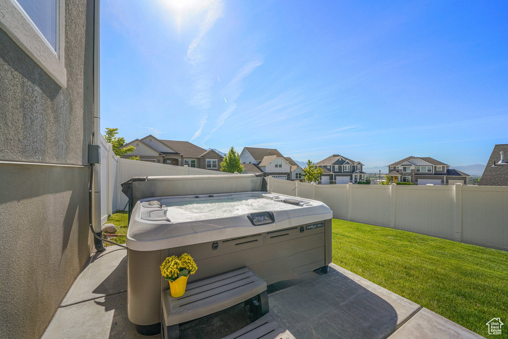 View of patio / terrace featuring a residential view and a hot tub