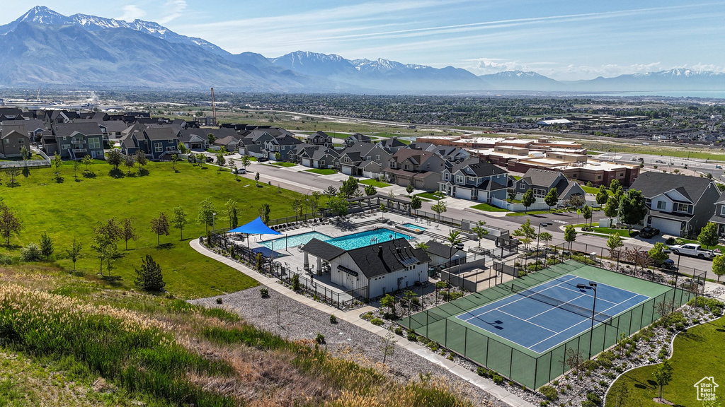 Aerial perspective of suburban area with a pool area and a mountainous background