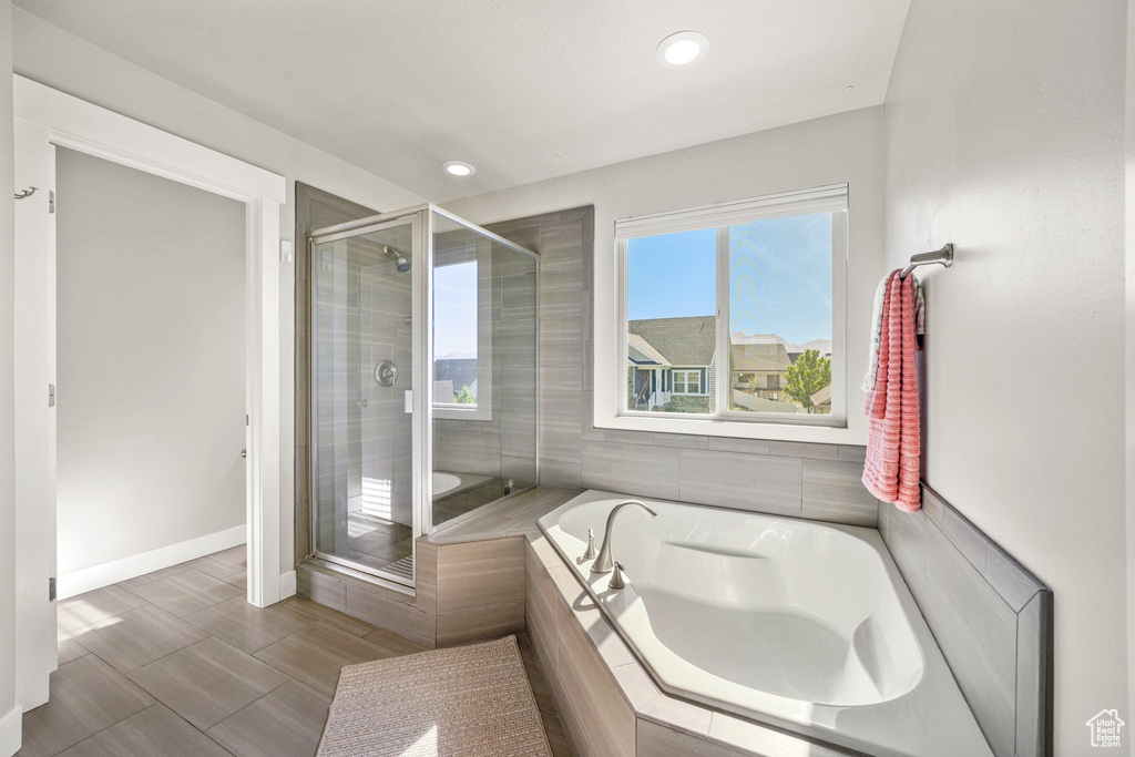 Full bath with a bath, a shower stall, baseboards, and recessed lighting