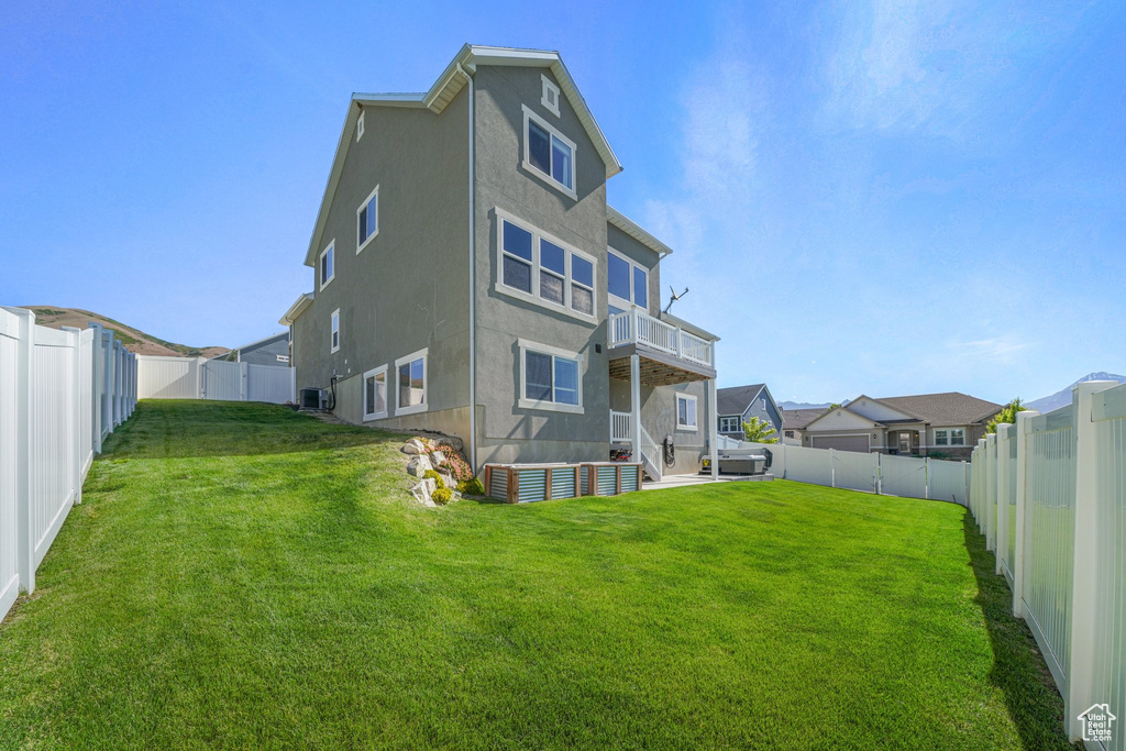 Rear view of house featuring stucco siding, cooling unit, and a residential view
