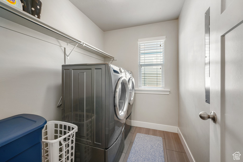 Laundry area with separate washer and dryer, baseboards, and wood finished floors