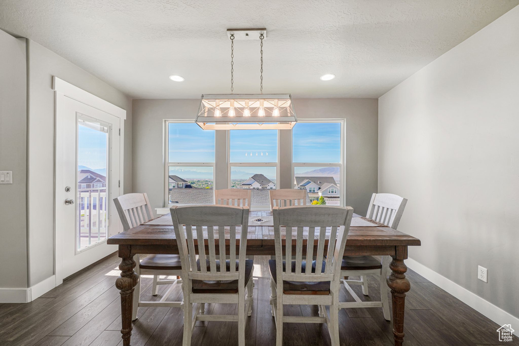 Dining area with dark wood finished floors, baseboards, and recessed lighting