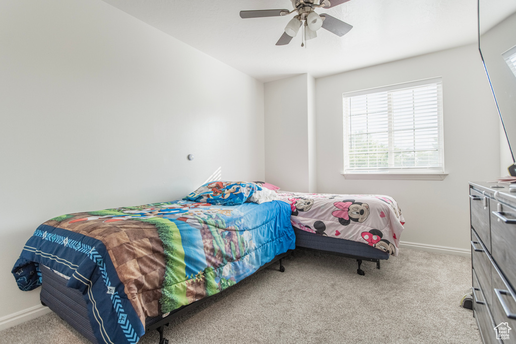 Bedroom featuring carpet flooring, baseboards, and ceiling fan