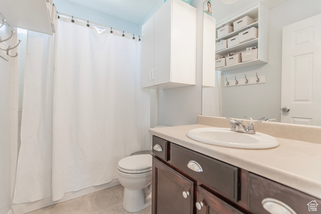 Full bathroom featuring vanity, toilet, shower / bath combo, and tile patterned flooring