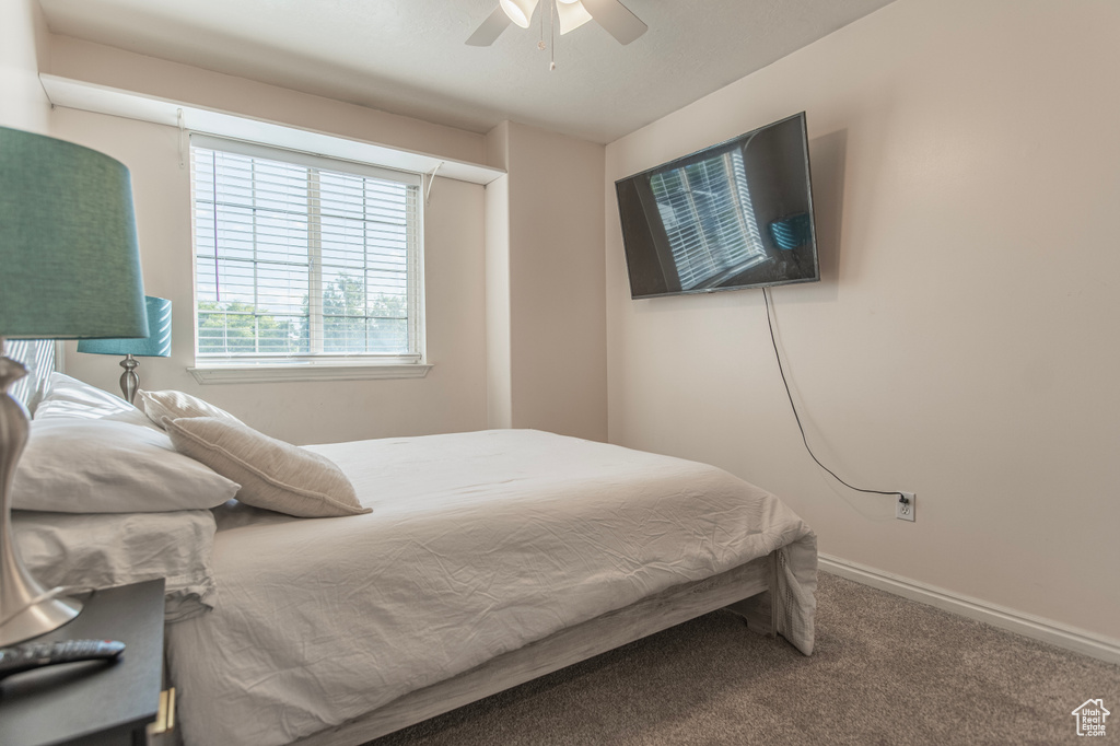 Carpeted bedroom with baseboards and a ceiling fan