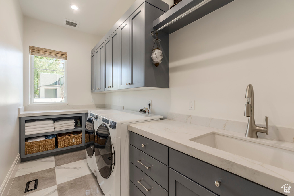Washroom with cabinet space, separate washer and dryer, light marble finish flooring, baseboards, and recessed lighting