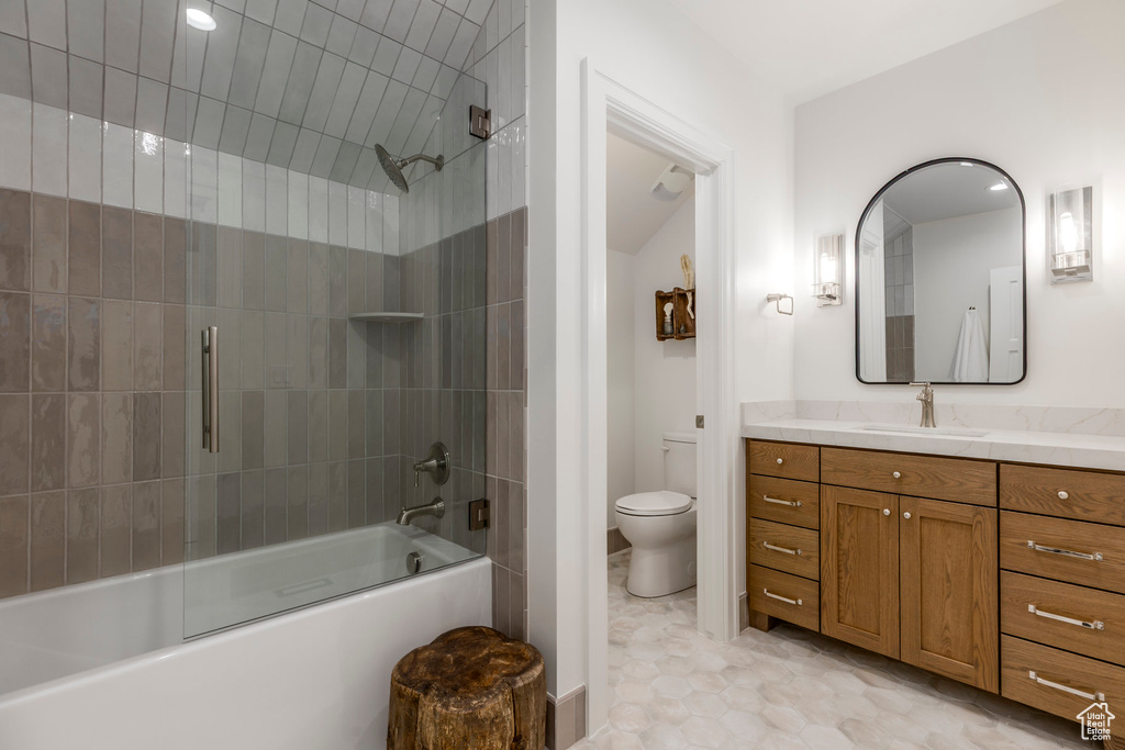 Full bathroom featuring toilet, vanity, and bath / shower combo with glass door