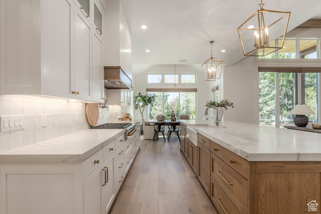 Kitchen featuring stainless steel gas cooktop, a chandelier, recessed lighting, backsplash, and a sink