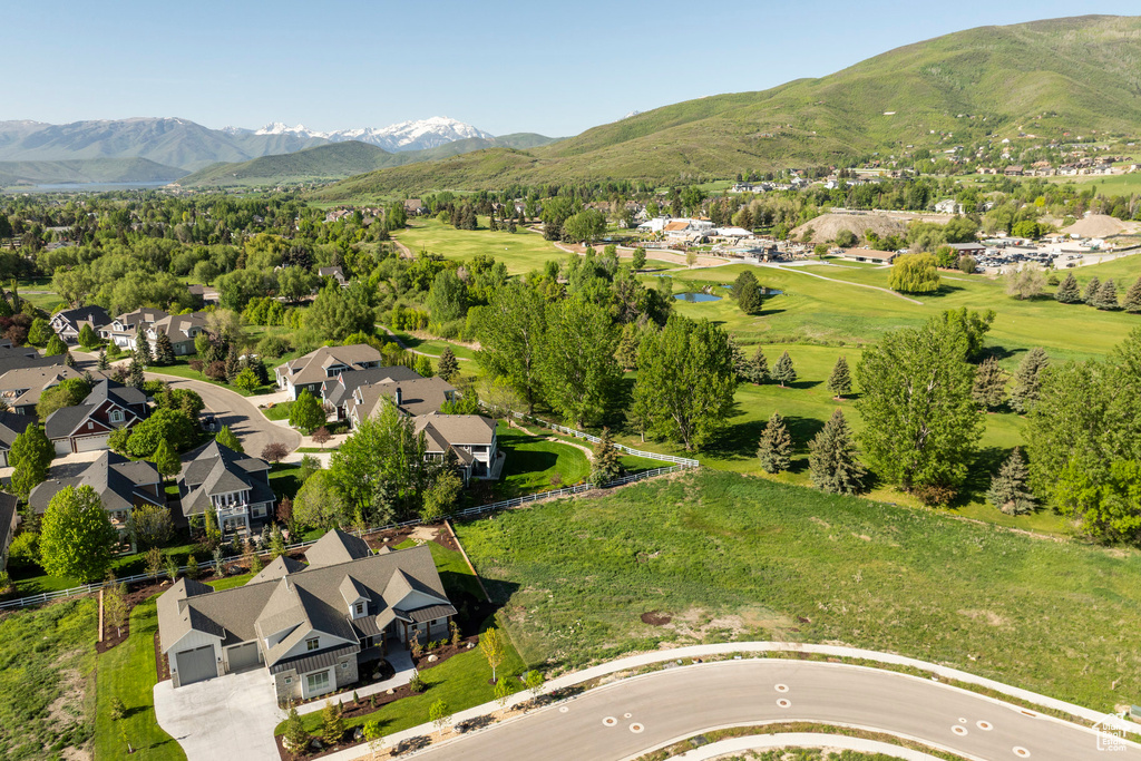 Aerial view of residential area featuring a golf course and a water and mountain view