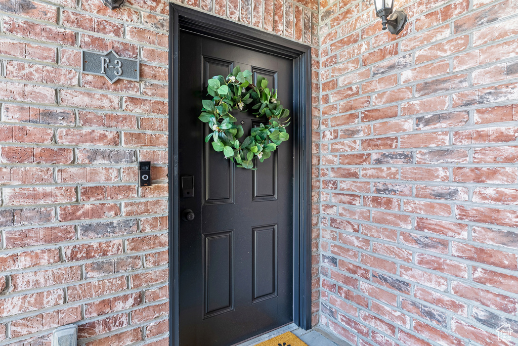 Doorway to property with brick siding