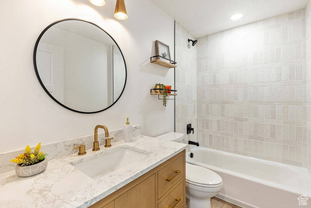 Full bath featuring toilet, vanity, and bathing tub / shower combination
