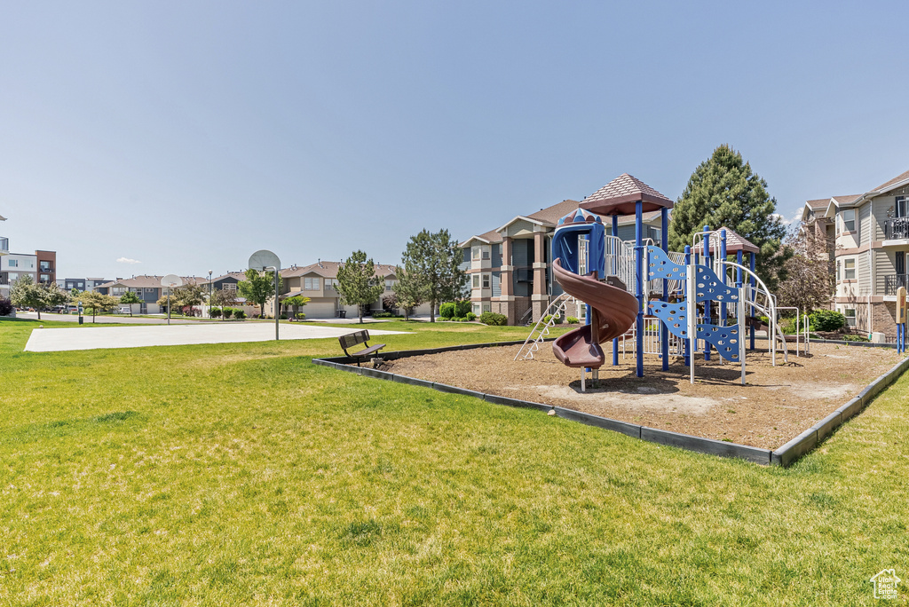 Communal playground with a yard and a residential view