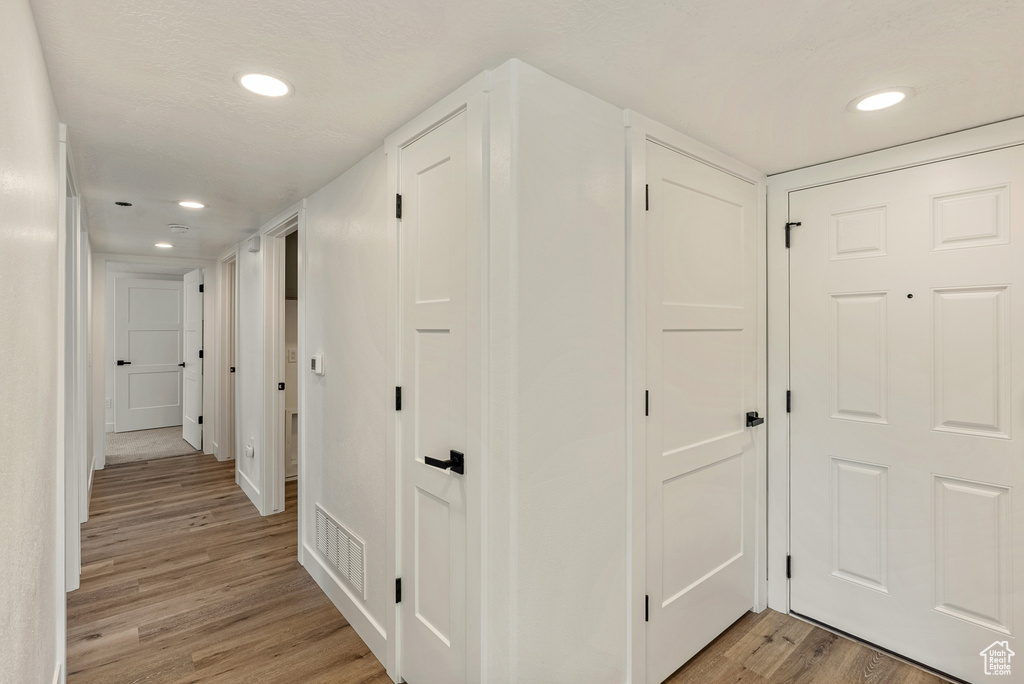 Hallway featuring light wood finished floors and recessed lighting