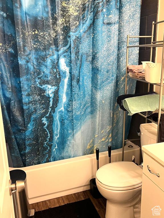 Bathroom with shower / tub combo with curtain, vanity, and toilet