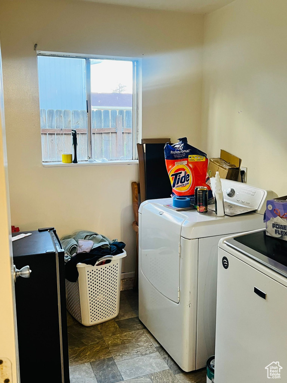 Laundry room featuring separate washer and dryer and stone finish floors