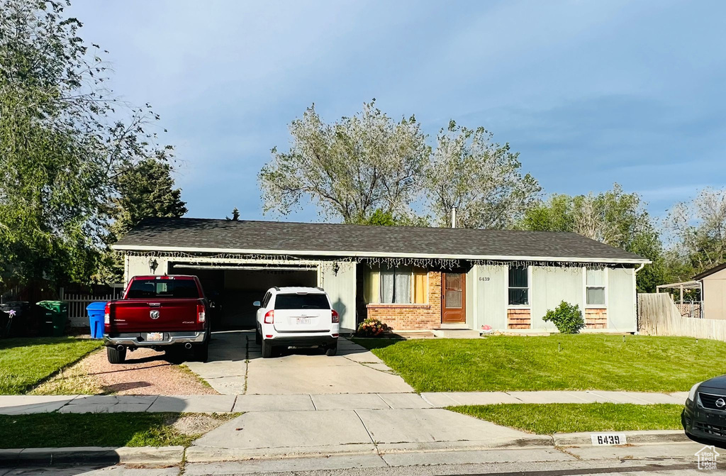 Ranch-style house with an attached garage, concrete driveway, brick siding, and roof with shingles