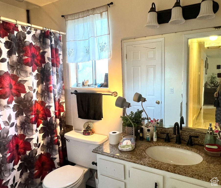 Full bath with vanity, toilet, and curtained shower