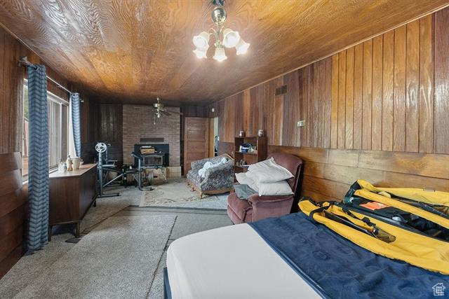 Bedroom featuring wooden walls, carpet flooring, and wooden ceiling