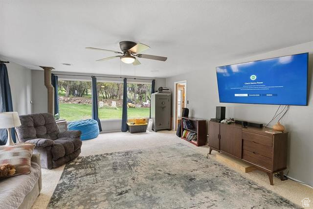 Carpeted living area with a ceiling fan