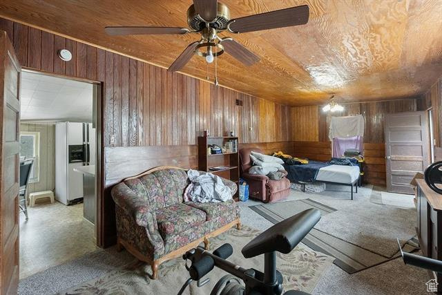 Sitting room with wood walls, wooden ceiling, and ceiling fan