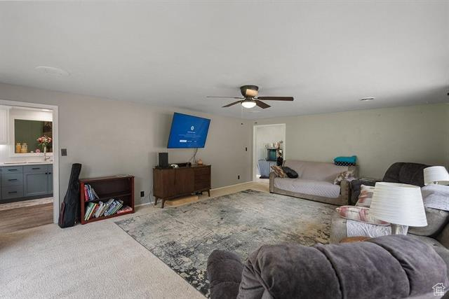 Living room with ceiling fan and light carpet