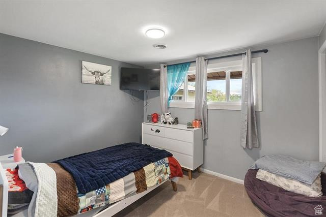 Bedroom with light carpet and baseboards