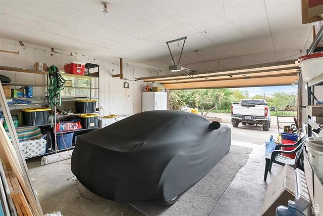 Garage with freestanding refrigerator and a garage door opener