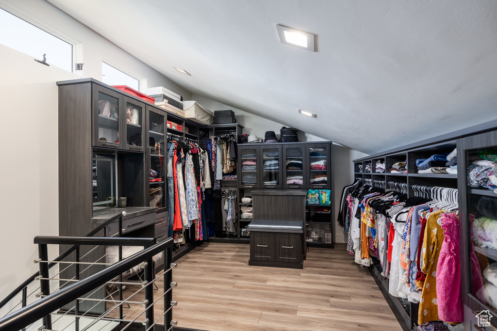 Spacious closet featuring wood finished floors and vaulted ceiling