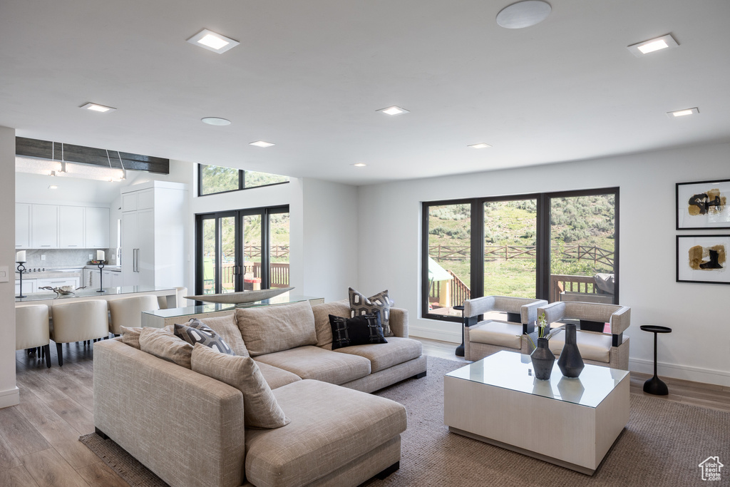 Living room with wood finished floors, baseboards, and recessed lighting