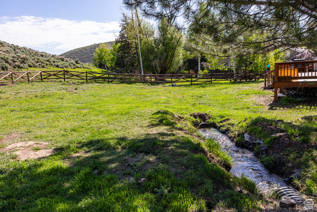 View of yard with a deck with mountain view