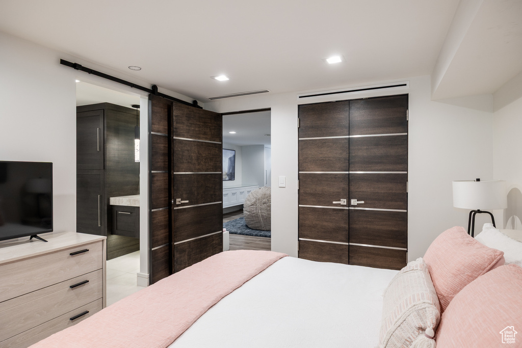 Bedroom with a barn door and recessed lighting