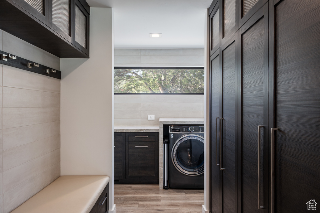 Laundry room with washer / dryer and light wood-style floors