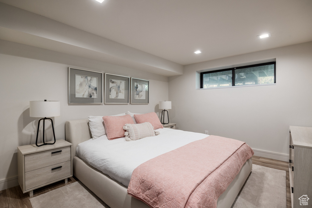 Bedroom with light wood finished floors, baseboards, and recessed lighting