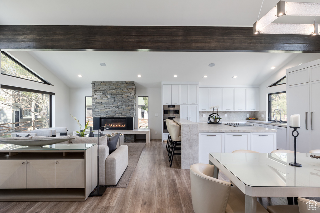 Kitchen with healthy amount of natural light, light wood-type flooring, white cabinetry, and recessed lighting