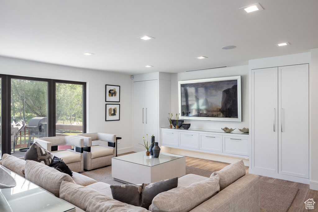 Living area with light wood finished floors, recessed lighting, and baseboards