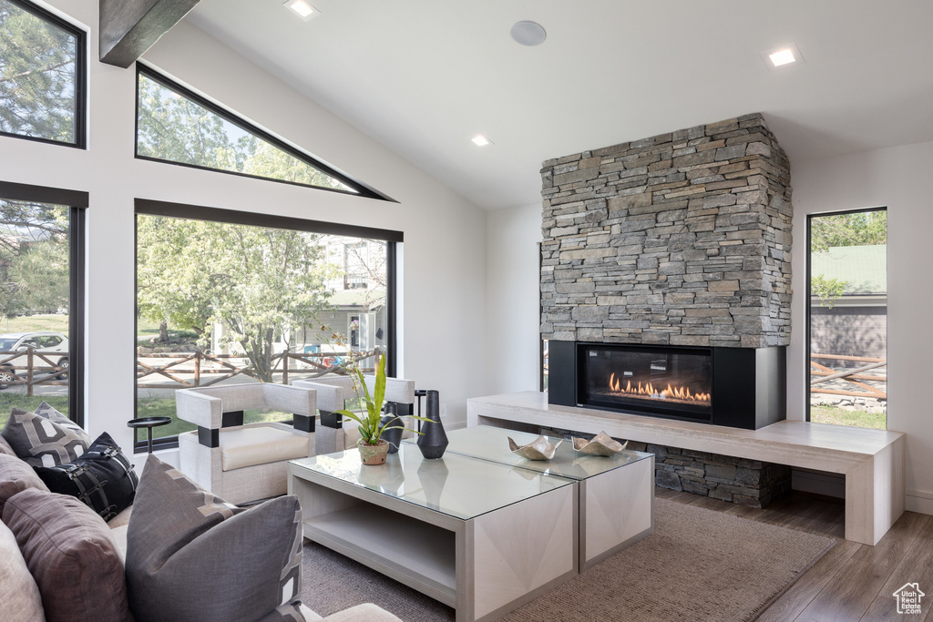 Living room with wood finished floors and a stone fireplace