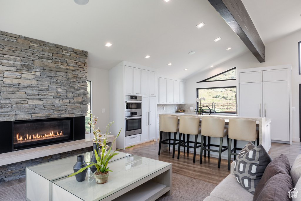 Living area featuring light wood-type flooring, a fireplace, and recessed lighting