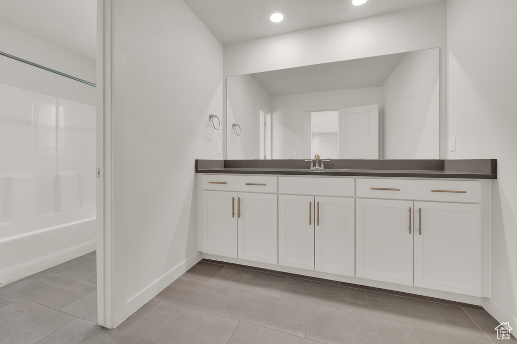 Full bath with vanity, baseboards, tile patterned floors, recessed lighting, and shower / tub combination