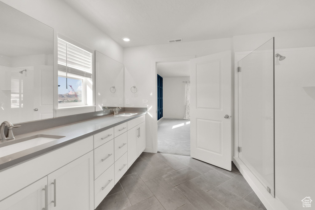 Full bath with double vanity, a stall shower, and recessed lighting