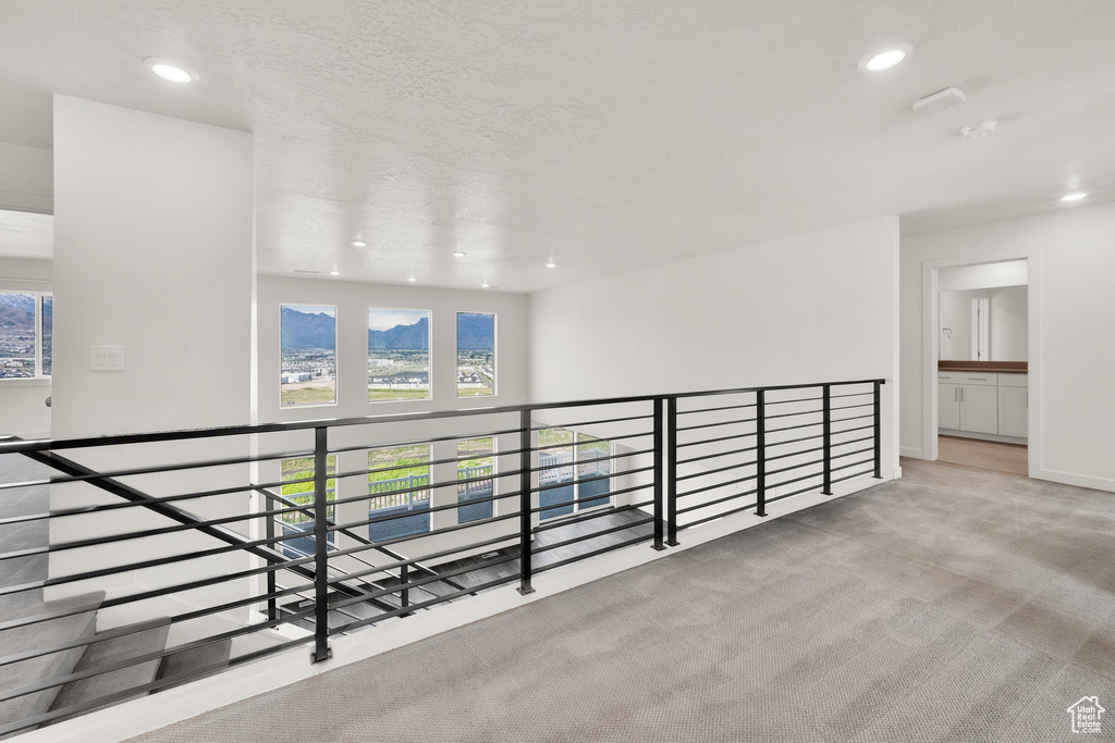 Hall featuring an upstairs landing, plenty of natural light, recessed lighting, carpet floors, and baseboards