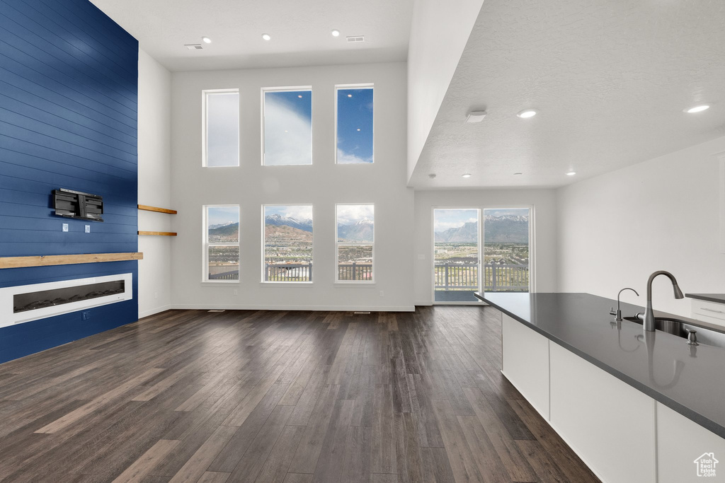Unfurnished living room with a sink, dark wood-style flooring, and recessed lighting