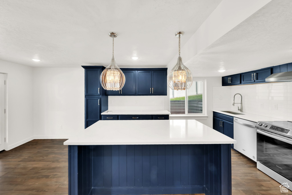 Kitchen with stainless steel electric stove, blue cabinets, dishwashing machine, a sink, and a chandelier