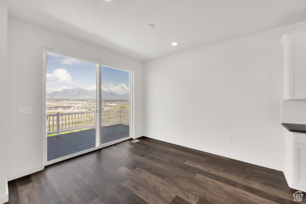 Spare room with dark wood-type flooring, recessed lighting, and baseboards
