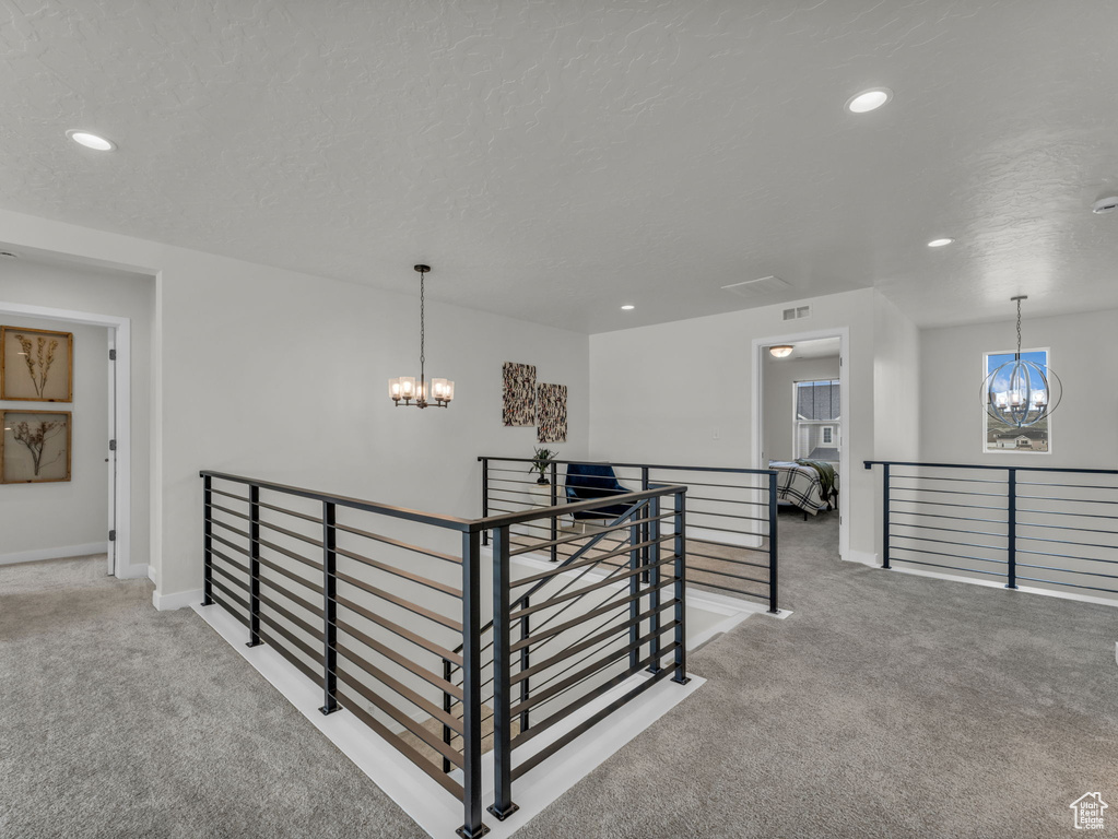Hallway with a chandelier, an upstairs landing, carpet, recessed lighting, and baseboards