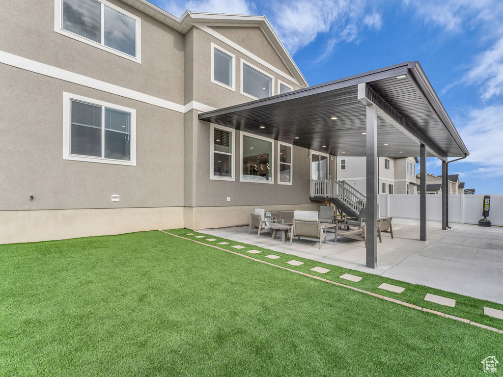 Back of property featuring a patio, outdoor lounge area, and stucco siding
