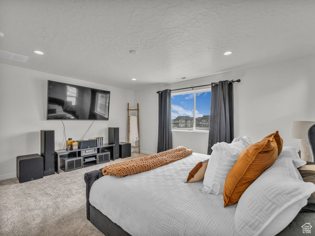 Carpeted bedroom with recessed lighting, baseboards, and a textured ceiling
