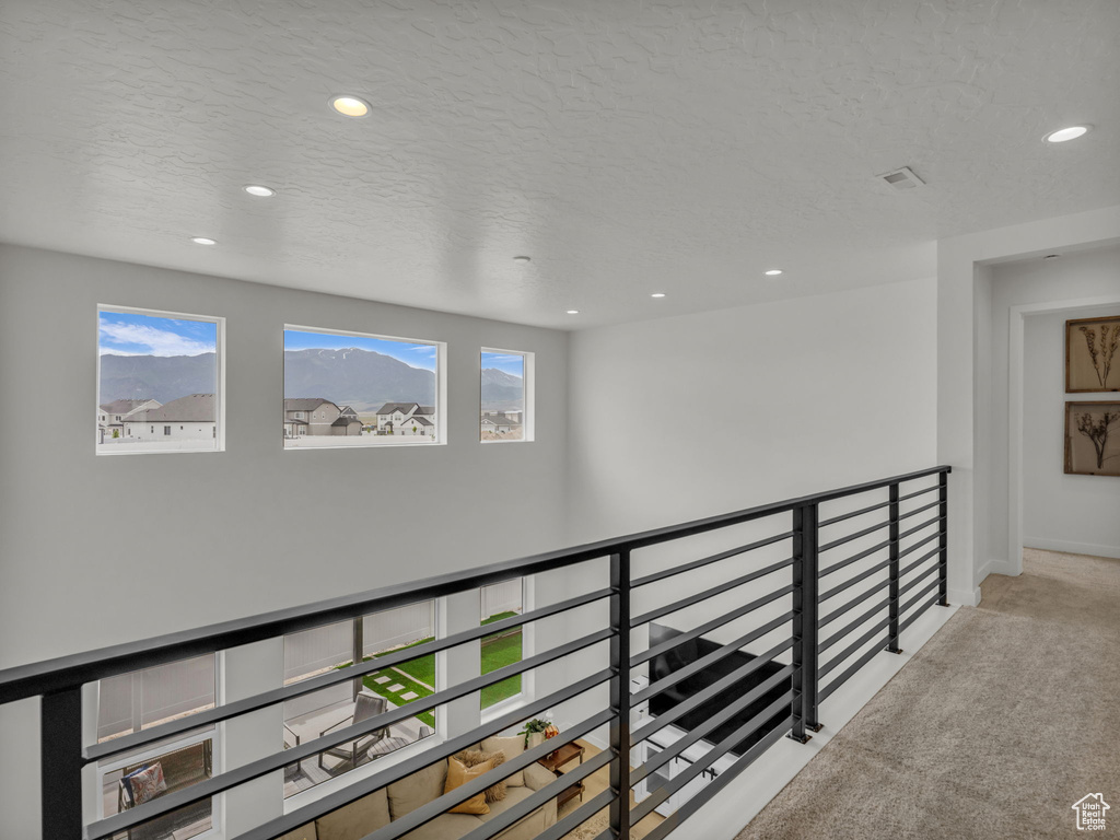 Hall with carpet flooring, recessed lighting, baseboards, and a textured ceiling