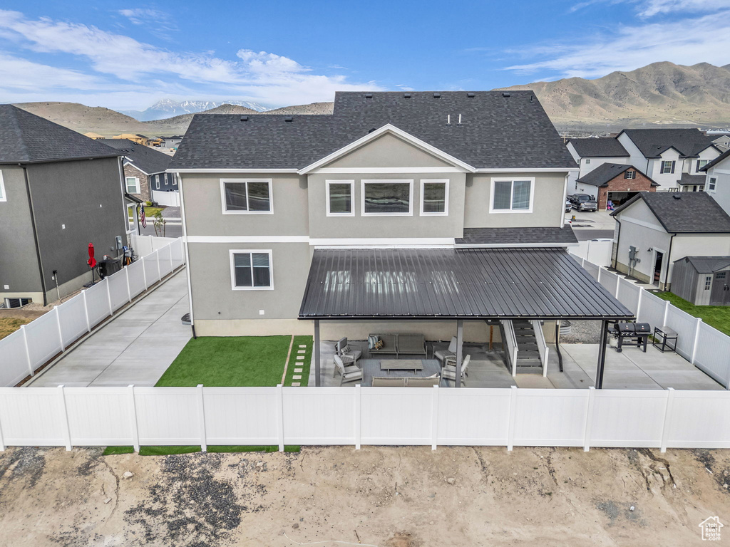 Rear view of property featuring a fenced backyard, a patio, and a mountain view