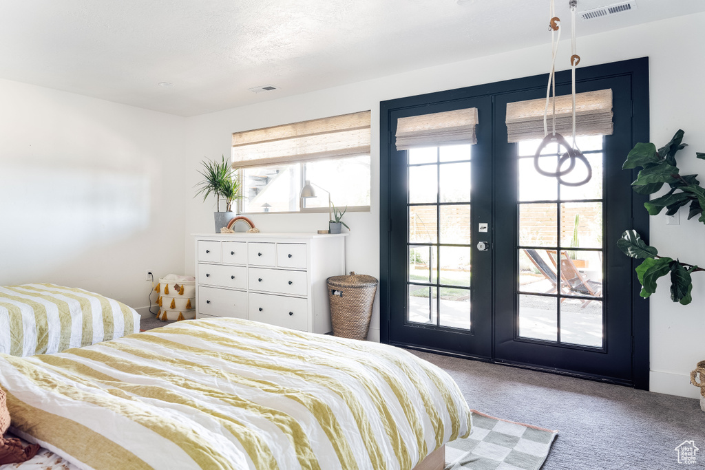 Bedroom featuring french doors, carpet flooring, multiple windows, and access to outside