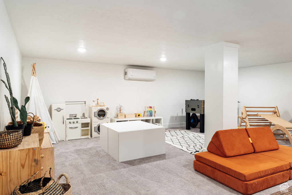 Home office with stacked washing machine and dryer, an AC wall unit, and light colored carpet